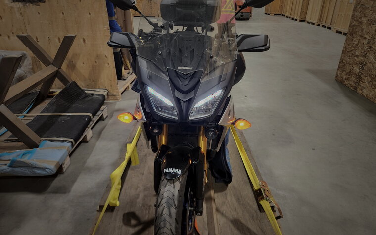 The front of a Yamaha adventure motorcycle secured on a lift in the crating shop